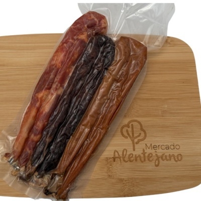 Três enchidos embalados a vácuo sobre tábua de madeira com logo Mercado Alentejano.