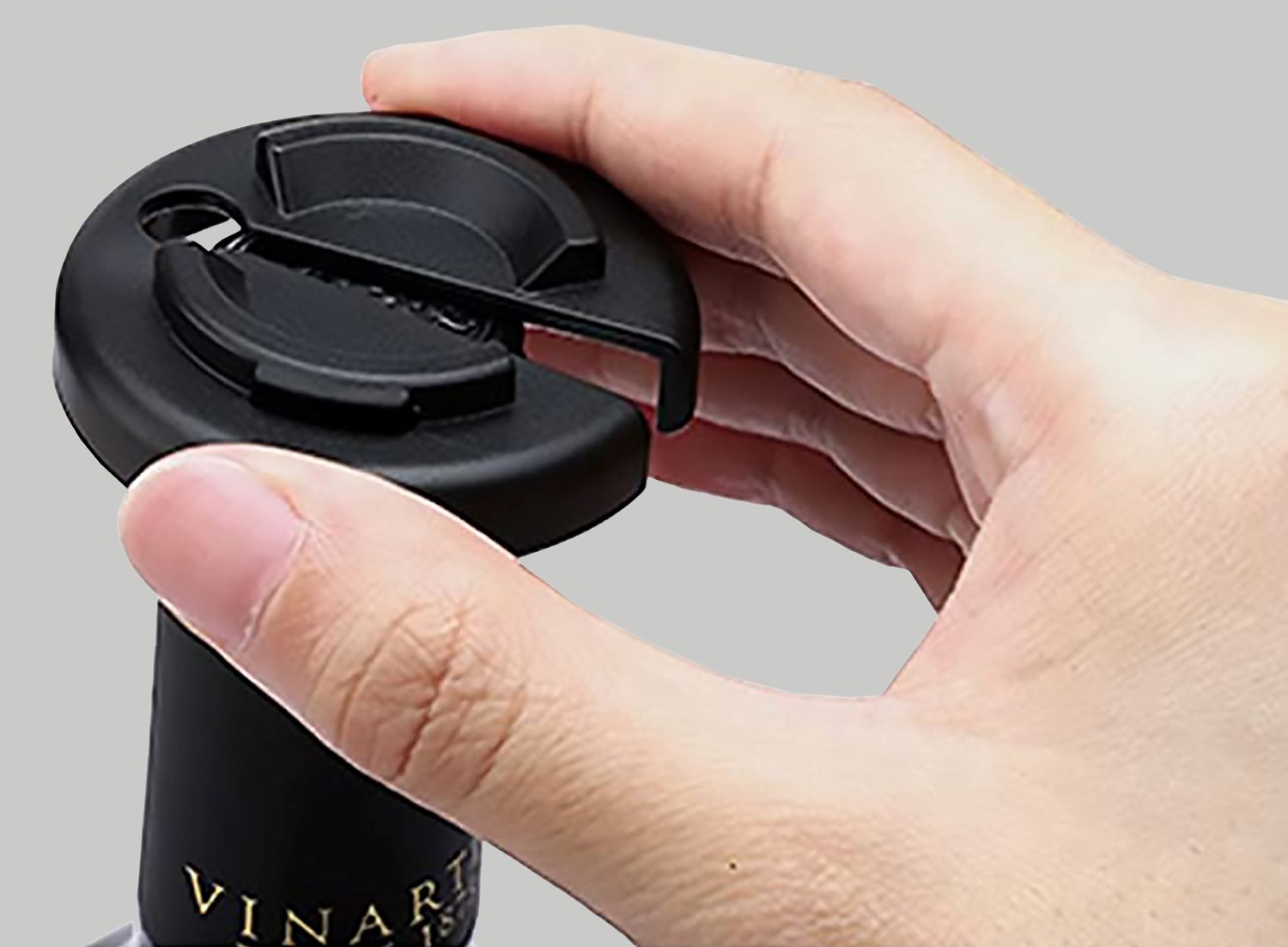 Saca-Rolhas Elétrico Vinak a Pilhas Mão segurando cortador preto num gargalo de garrafa de vinho.