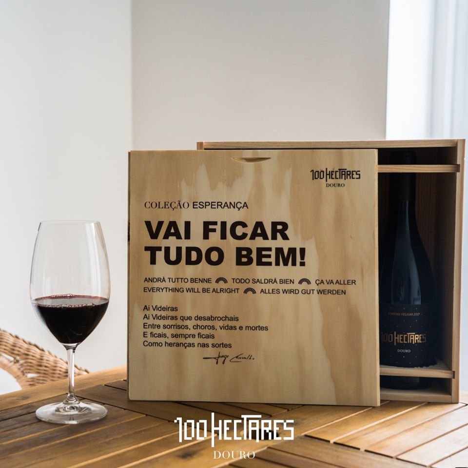 Conjunto 3 Garrafas 100 Hectares Coleção Esperança Caixa de madeira com garrafa de vinho 100 HECTARES DOURO e copo de vinho tinto na mesa