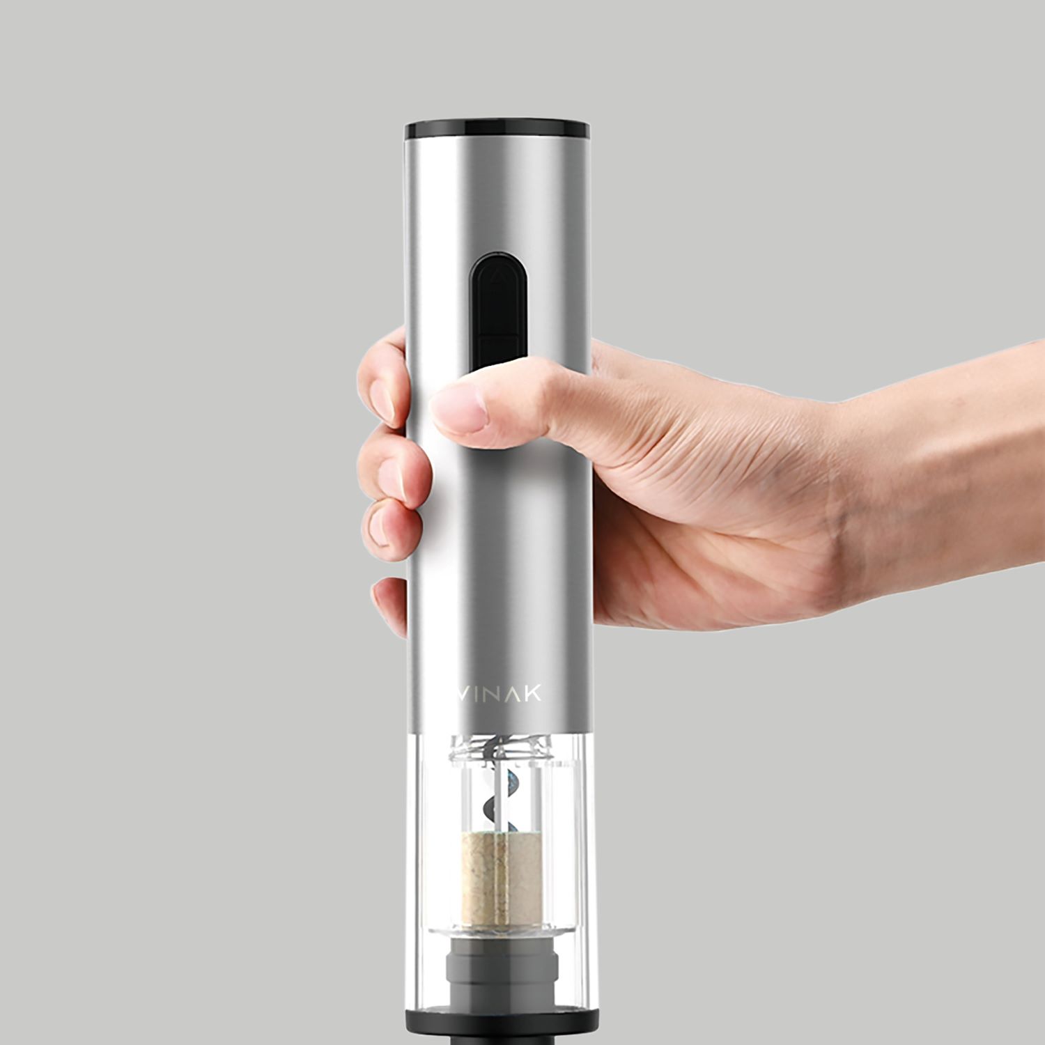 Kit Wine Set Vinak a Pilhas Moinho elétrico de sal ou pimenta prateado com visor transparente, segurado por uma mão.