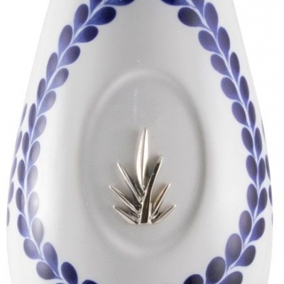 Peça de cerâmica branca com decoração azul e ornamento prateado no centro