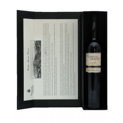 Garrafa de vinho tinto em caixa preta com texto explicativo em papel dobrado.