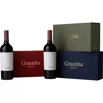 Duas garrafas de vinho e três caixas Grainha Reserva em cores vermelho, verde e azul escuro.