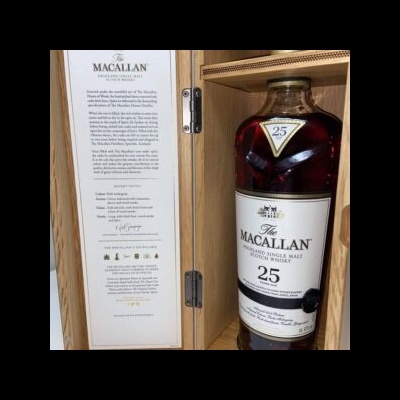 Garrafa de whisky Macallan 25 anos dentro de caixa de madeira clara com texto explicativo