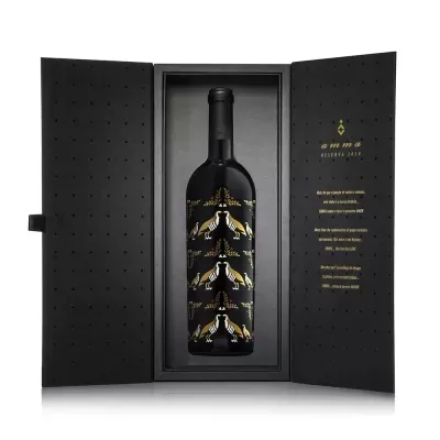Garrafa de vinho tinto em caixa preta aberta com texto dourado