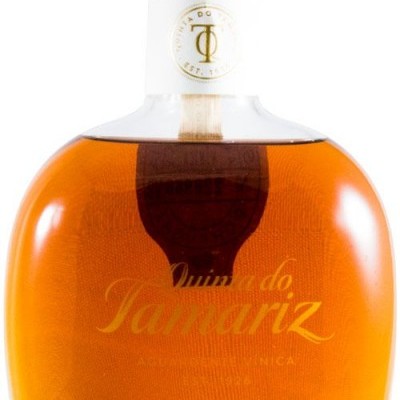 Garrafa de vidro com líquido âmbar e texto Quinta do Tamariz