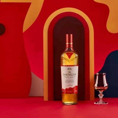 garrafa de whisky The Macallan Triple Cask 12 Anos Earth com copo pequeno em fundo geométrico
