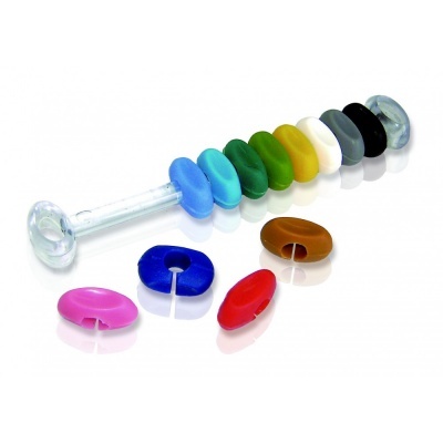 Anéis coloridos de silicone empilhados num tubo com anéis soltos ao lado, fundo branco