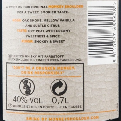 Etiqueta bege texturizada de whisky Monkey Shoulder com texto em inglês e alemão, código de barras, e percentagem de álcool 40% VOL