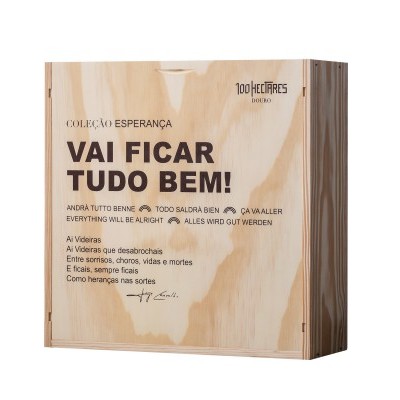 Caixa de madeira clara com texto motivacional em várias línguas