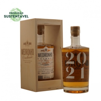 Garrafa de vidro com líquido âmbar e embalagem de madeira aberta mostrando outra garrafa etiquetada