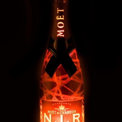 Garrafa de champanhe Moët & Chandon N.I.R iluminada sobre fundo escuro