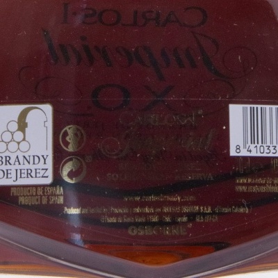 Garrafa de vidro com rótulo branco e líquido castanho escuro