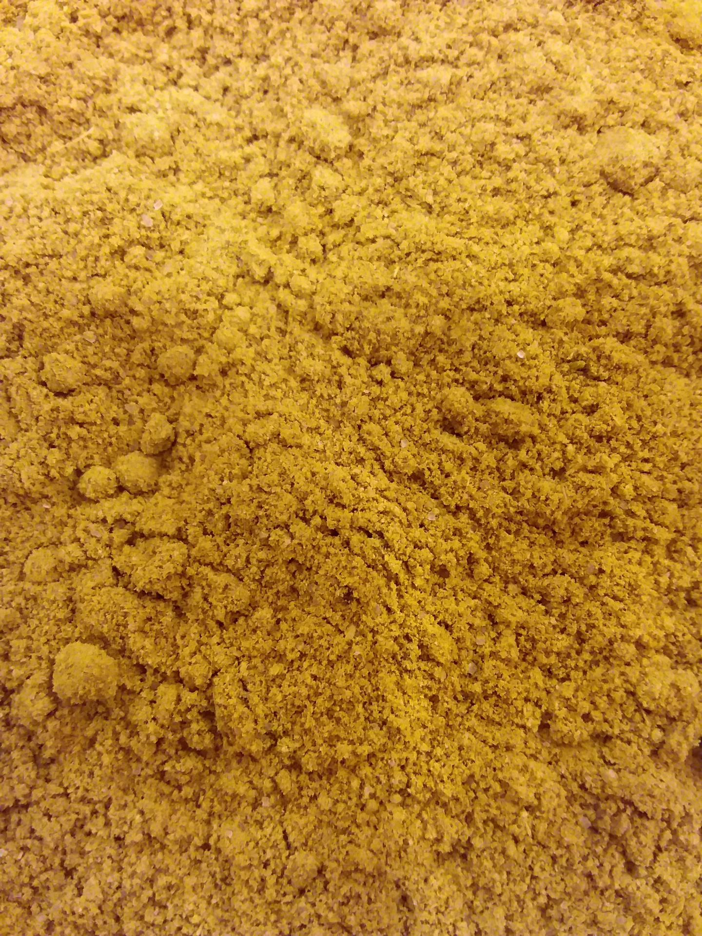 Pó granulado amarelo-alaranjado com textura fina