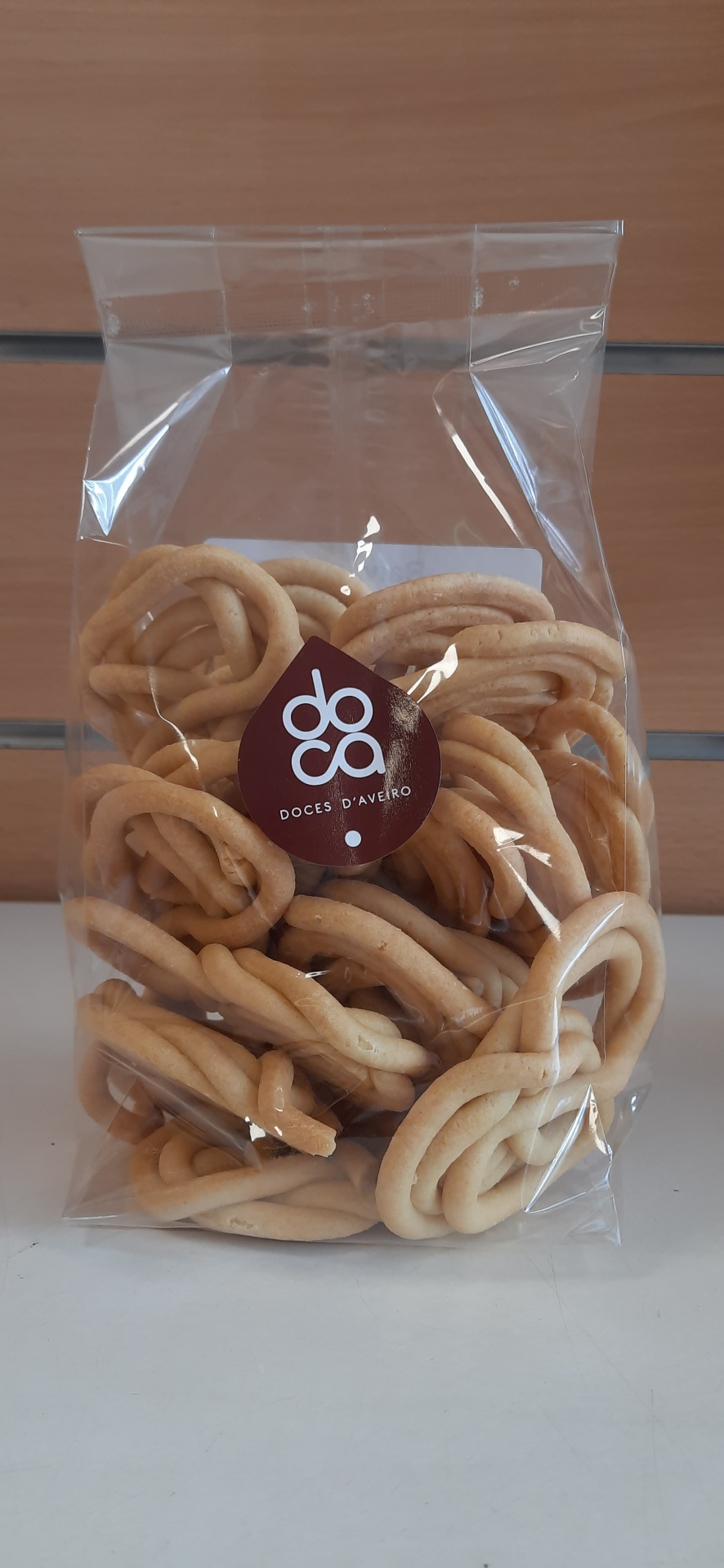 Pacote transparente com doces tradicionais castanhos claros com etiqueta roxa