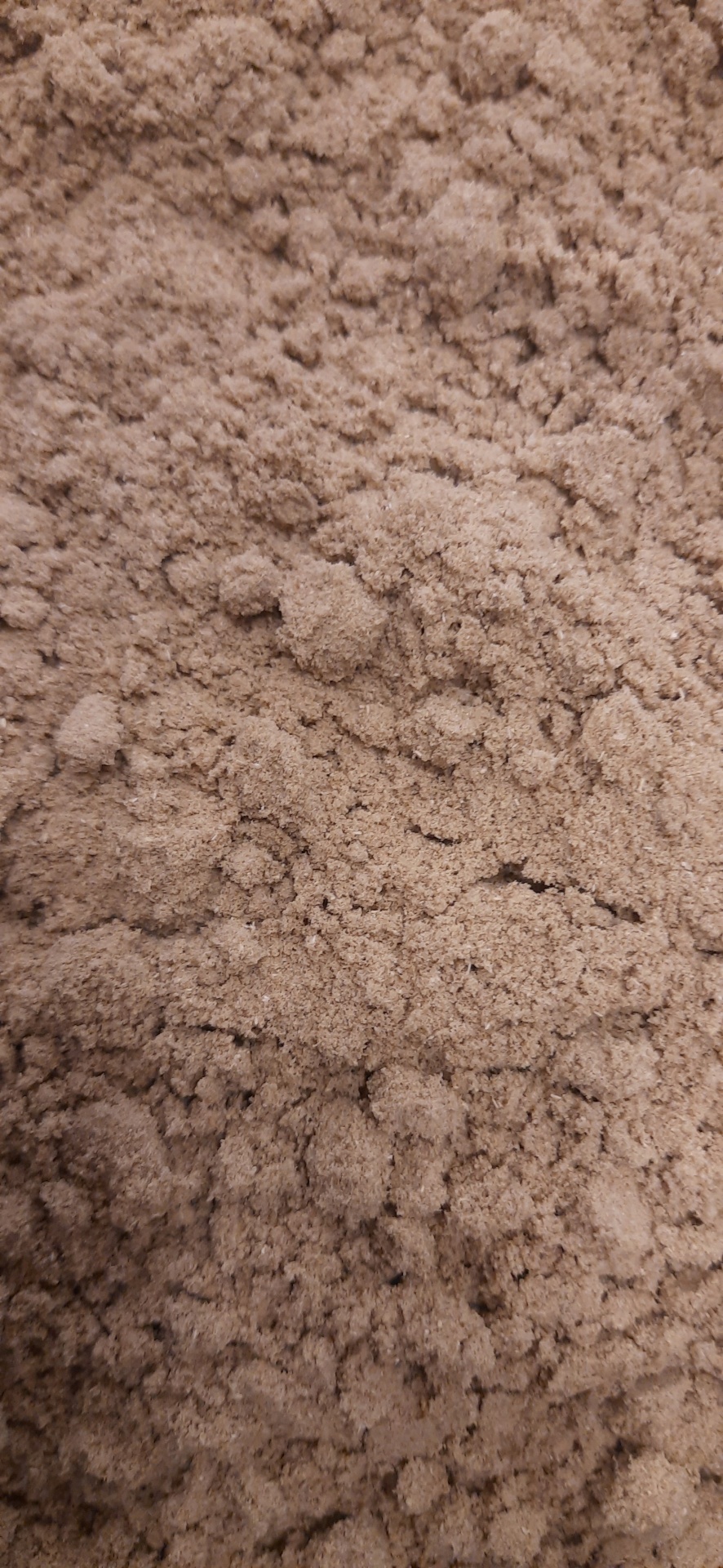 Pó castanho claro com textura granulada