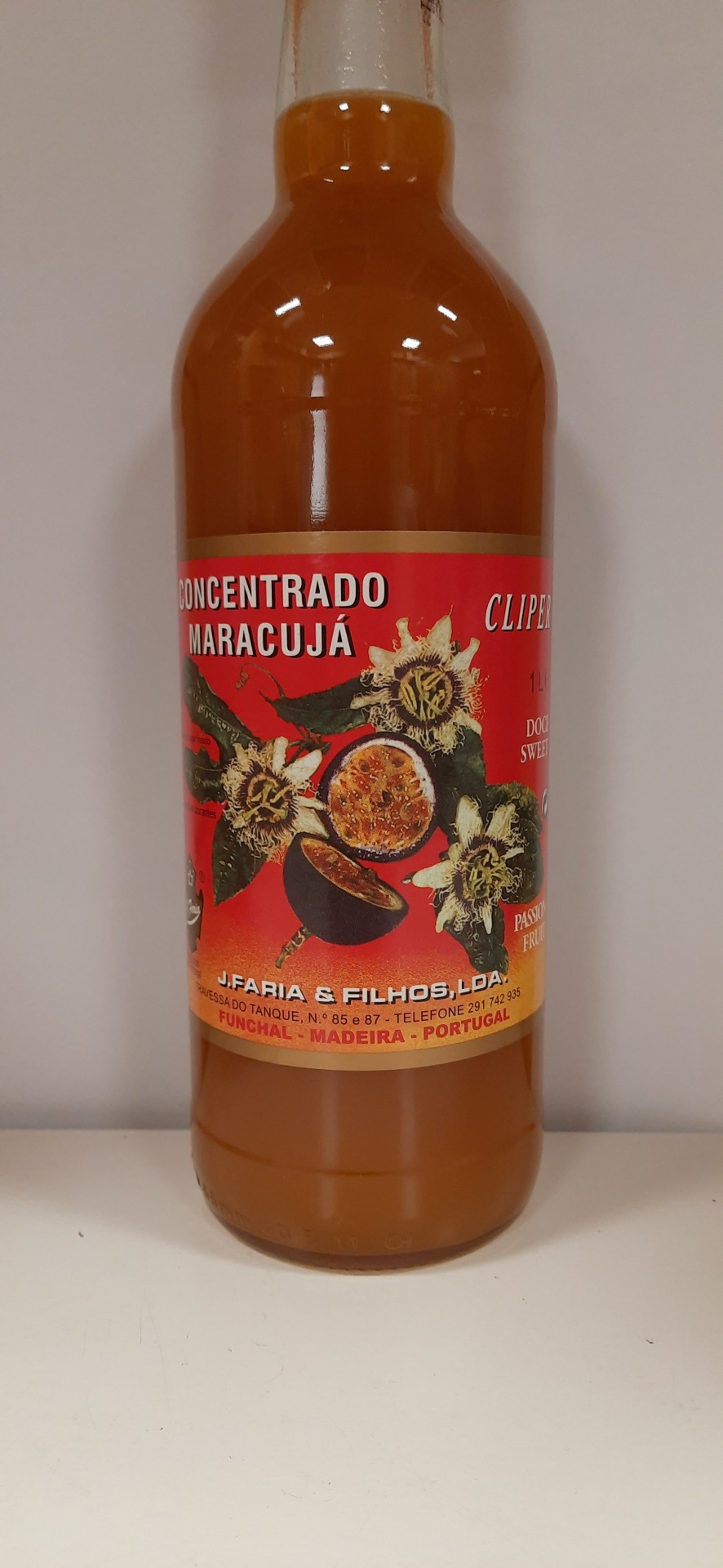 Garrafa de concentrado de maracujá com rótulo colorido e texto legível