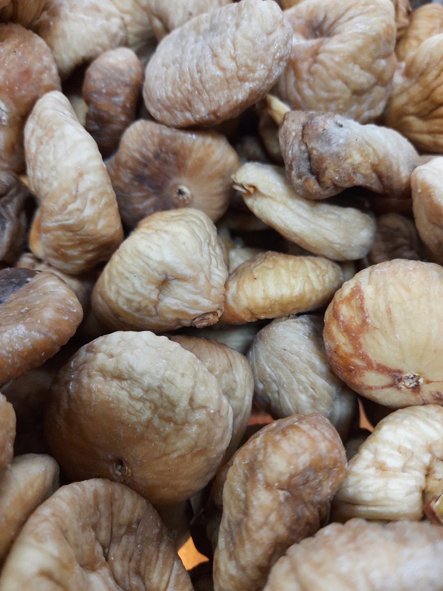 Figos secos cinza-acinzentados e bege com textura enrugada e empilhados