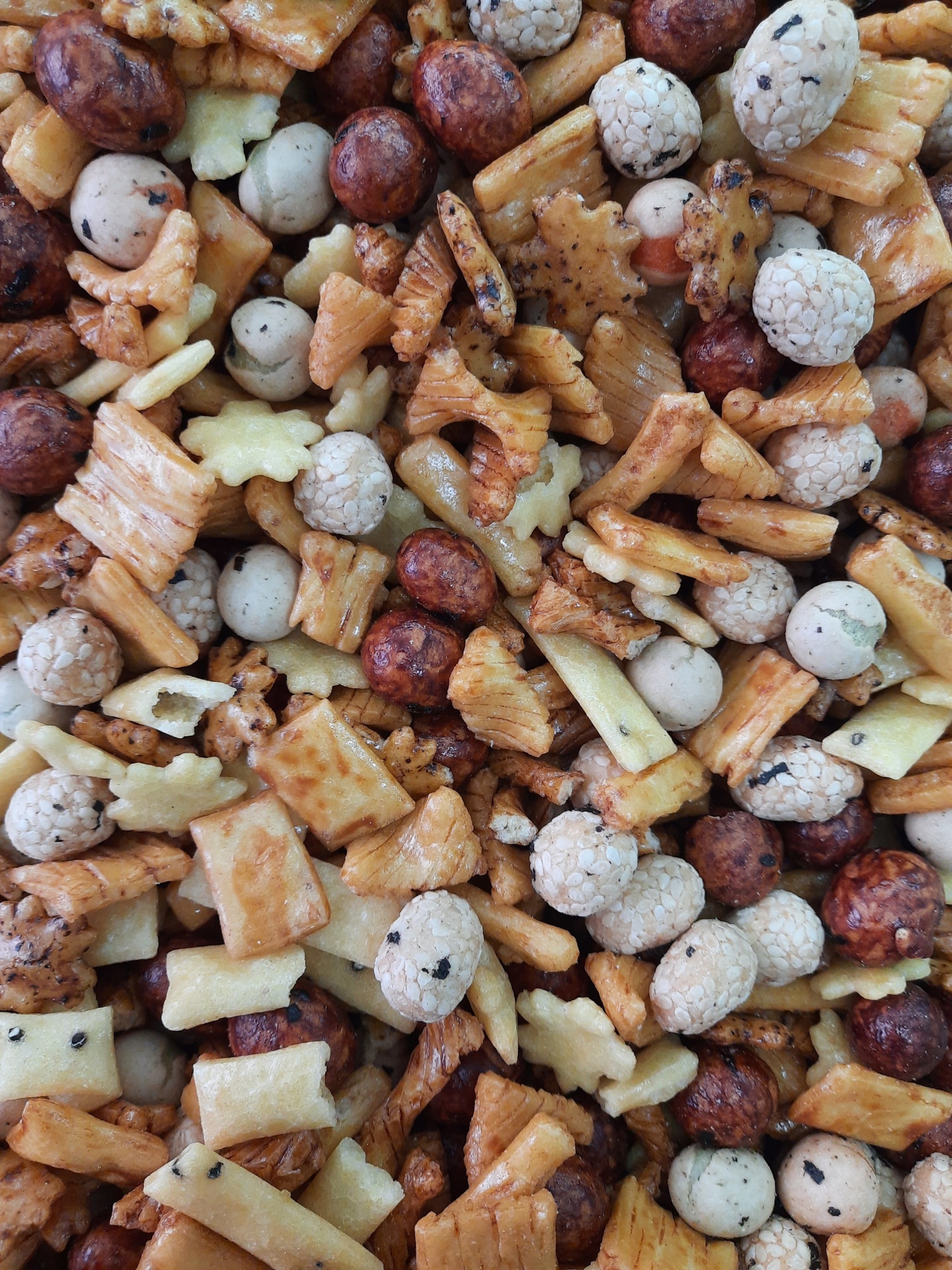 Mix de snacks asiáticos variados com bolinhas e peças crocantes em tons dourados e bege