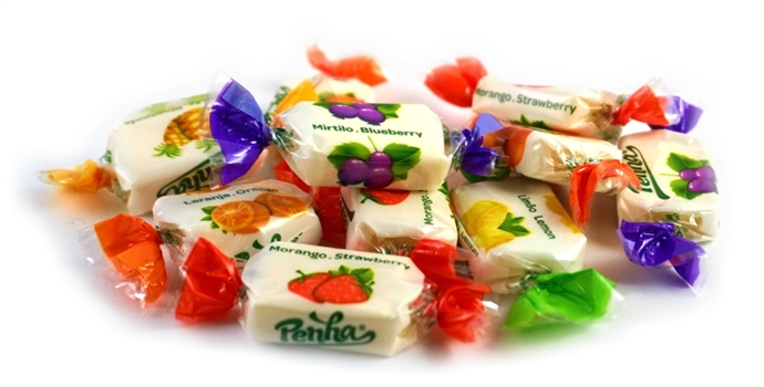 Rebuçados embalados com várias cores e imagens de morango e mirtilo