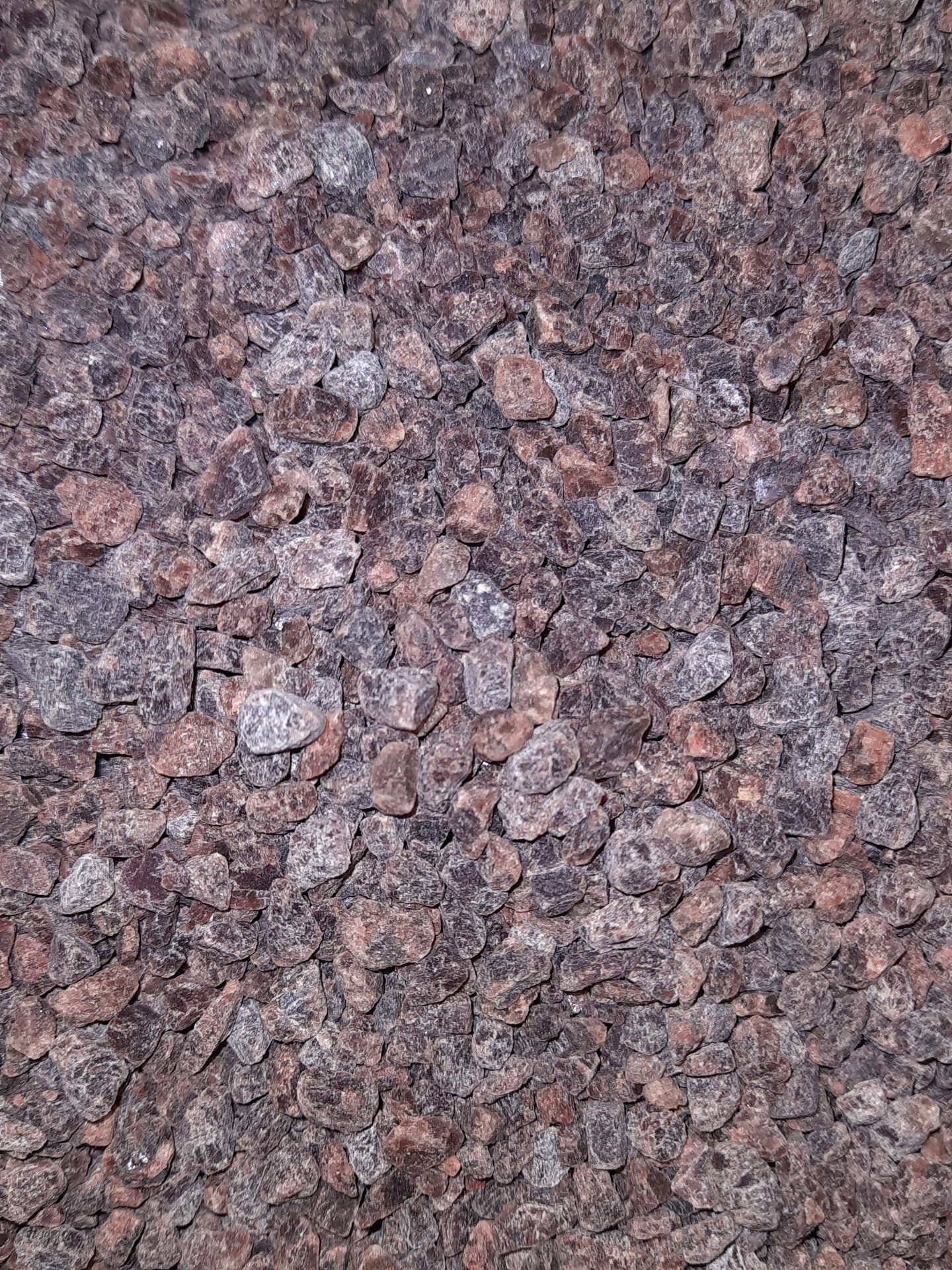 Pequenas pedras decorativas castanhas e cinzentas com textura rugosa