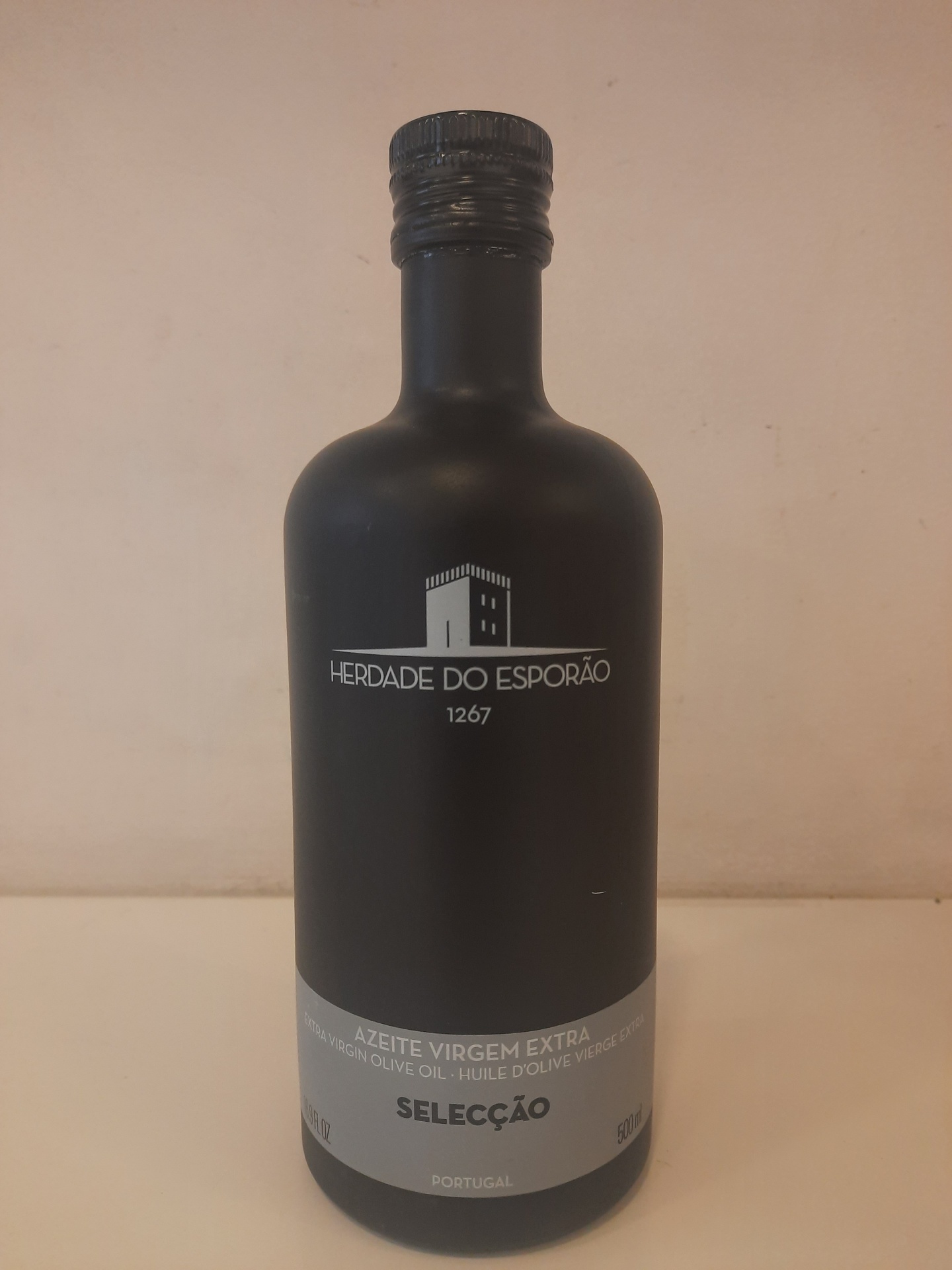 Garrafa preta fosca de azeite virgem extra com rótulo cinza e texto branco