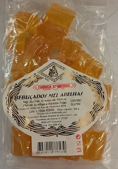 Pacote de doces de mel alaranjados em embalagem transparente com rótulo branco e preto da FABRICA S ANTONIO