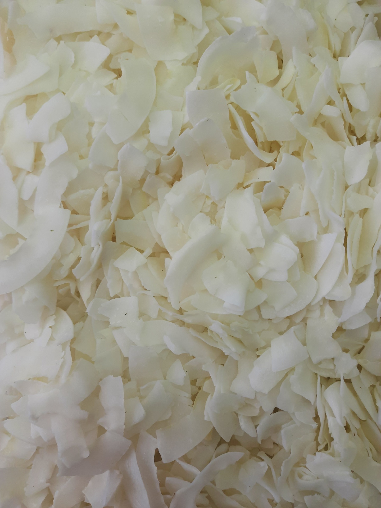 Flocos de coco seco brancos e creme em close-up