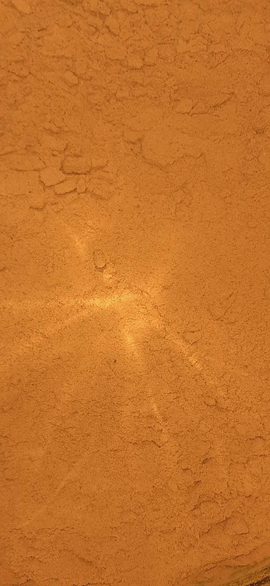 Pó fino alaranjado com textura irregular