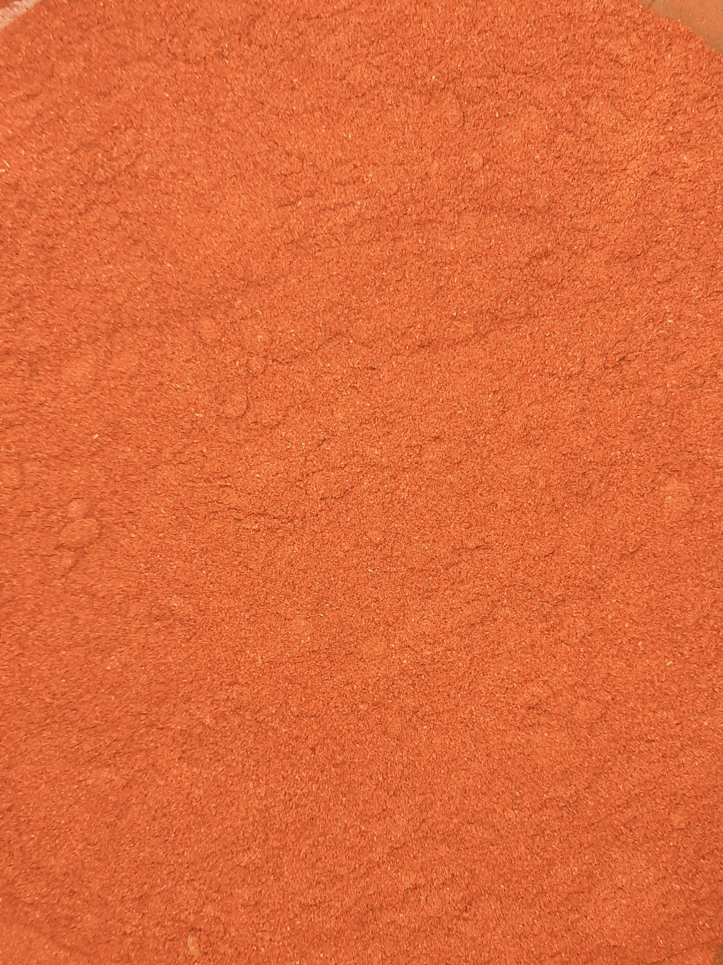 Pó fino laranja-avermelhado granuloso