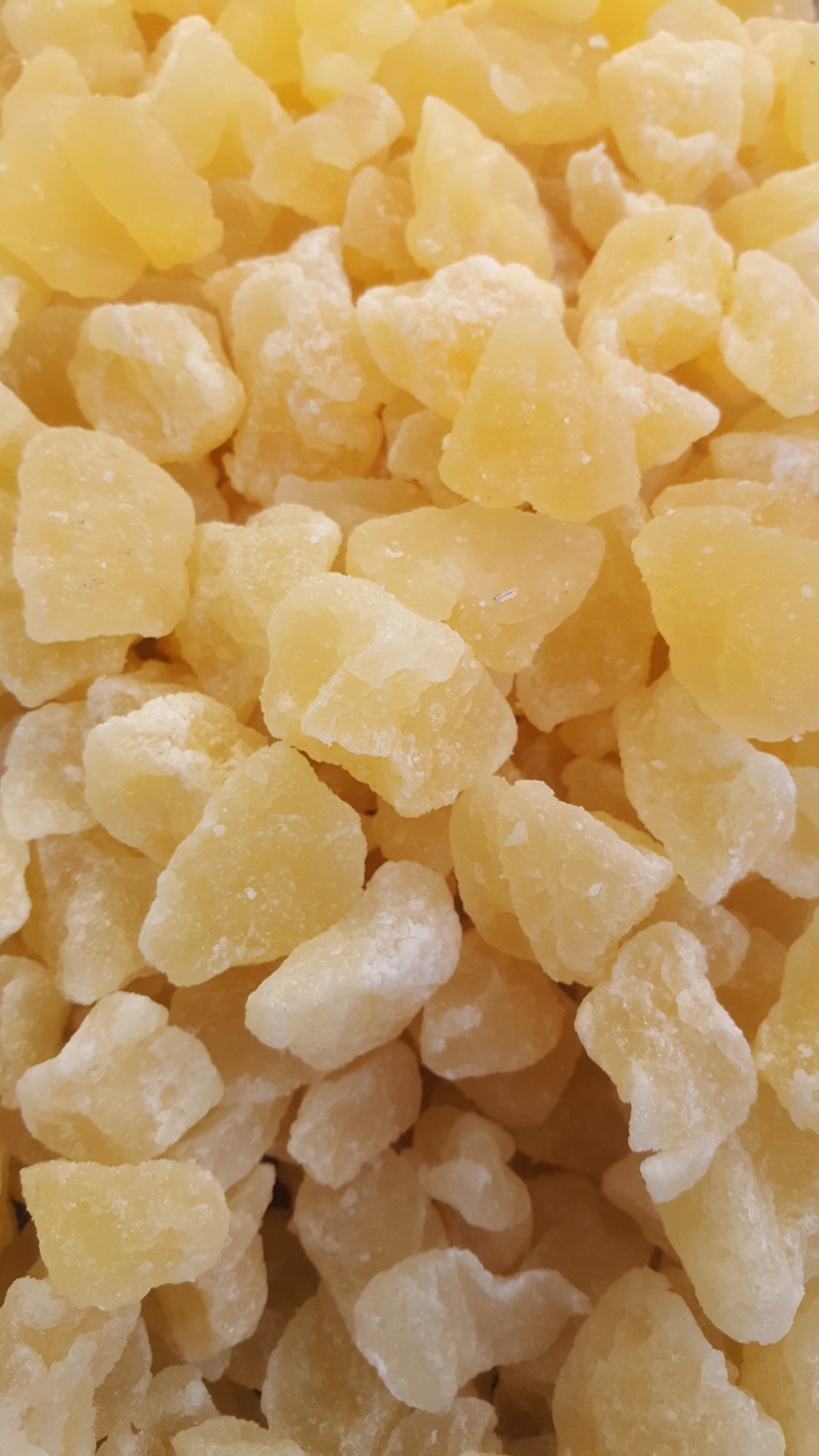 Pedaços irregulares de fruta cristalizada amarela clara em close-up