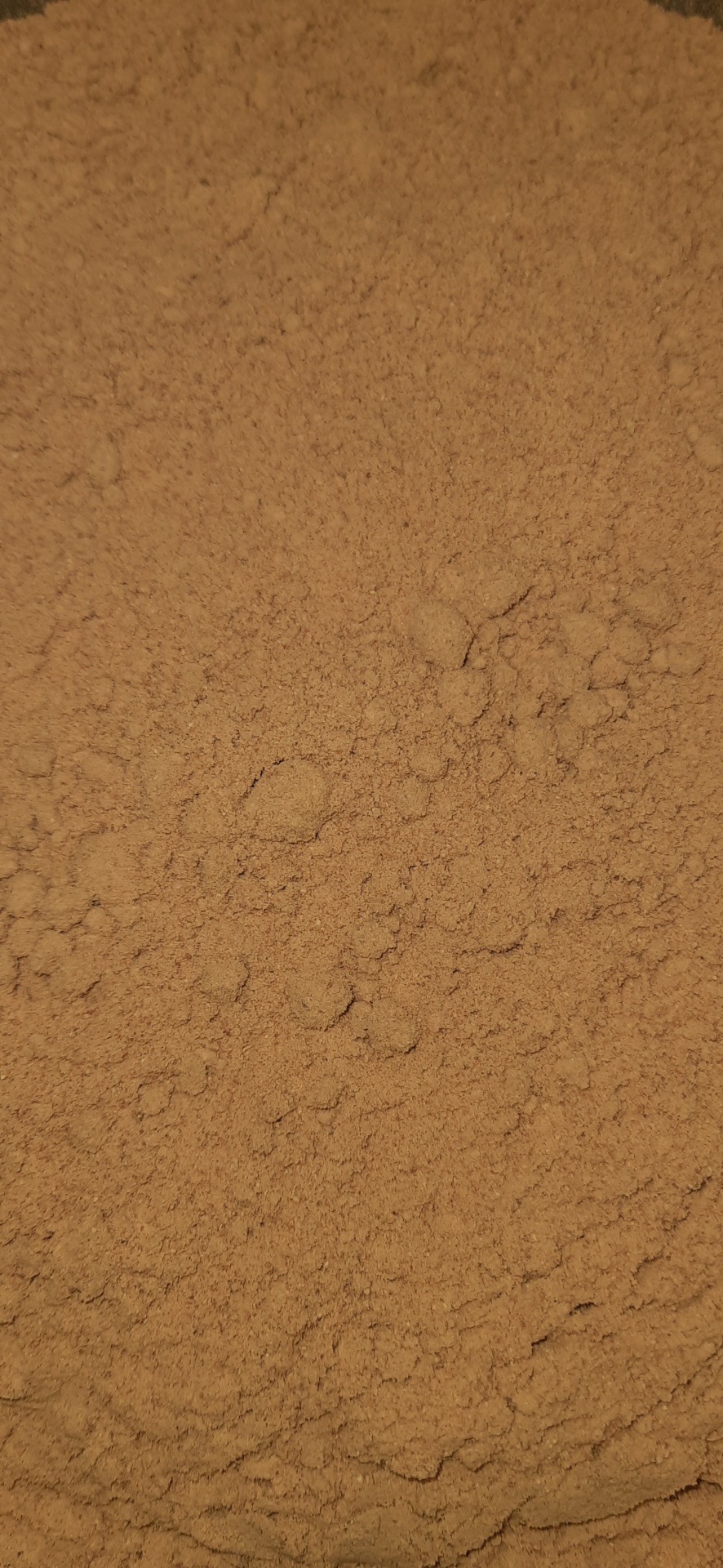 Pó fino castanho claro com textura granulada