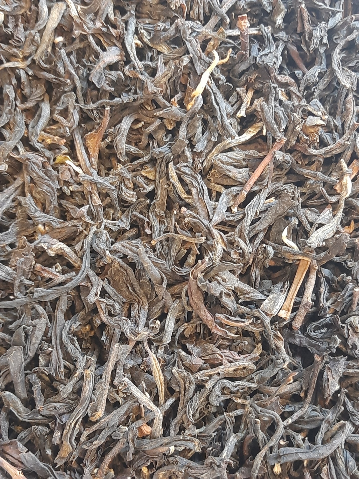 Chá preto solto com folhas enroladas castanho e preto