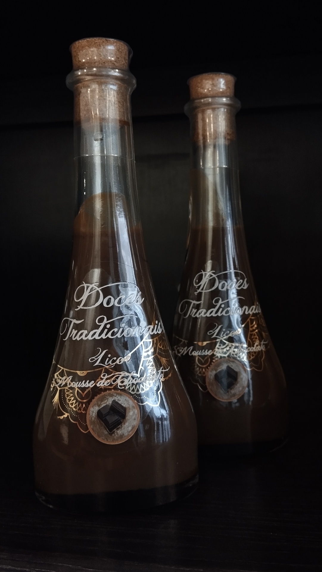 Duas garrafas de vidro com licor mousse de chocolate e tampas de cortiça