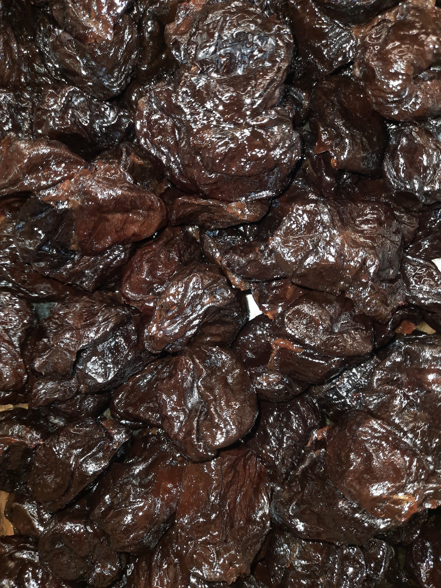 Ameixas secas castanho escuras com textura enrugada