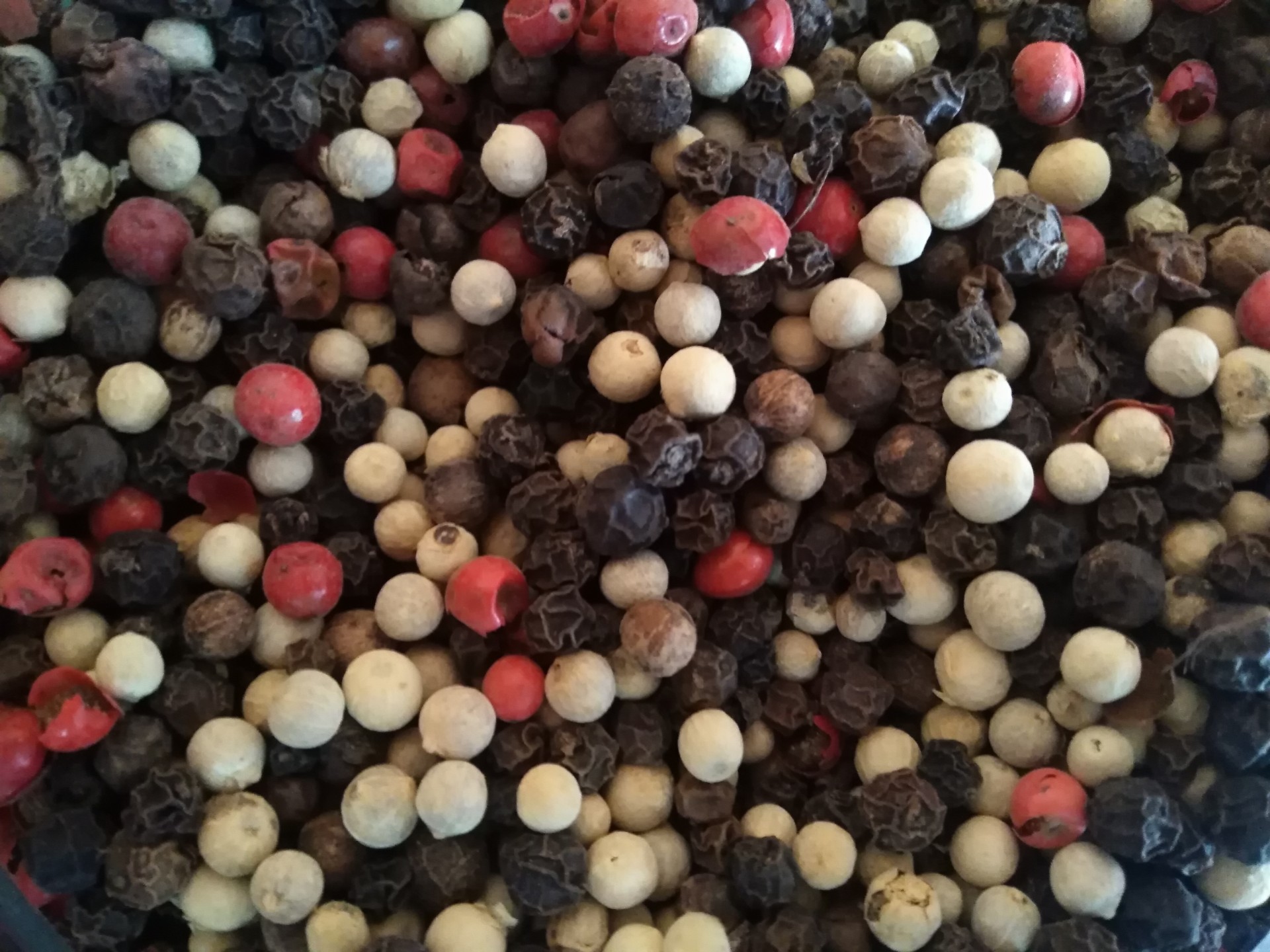 Mistura de pimentos em grão preto, branco e vermelho com textura rugosa