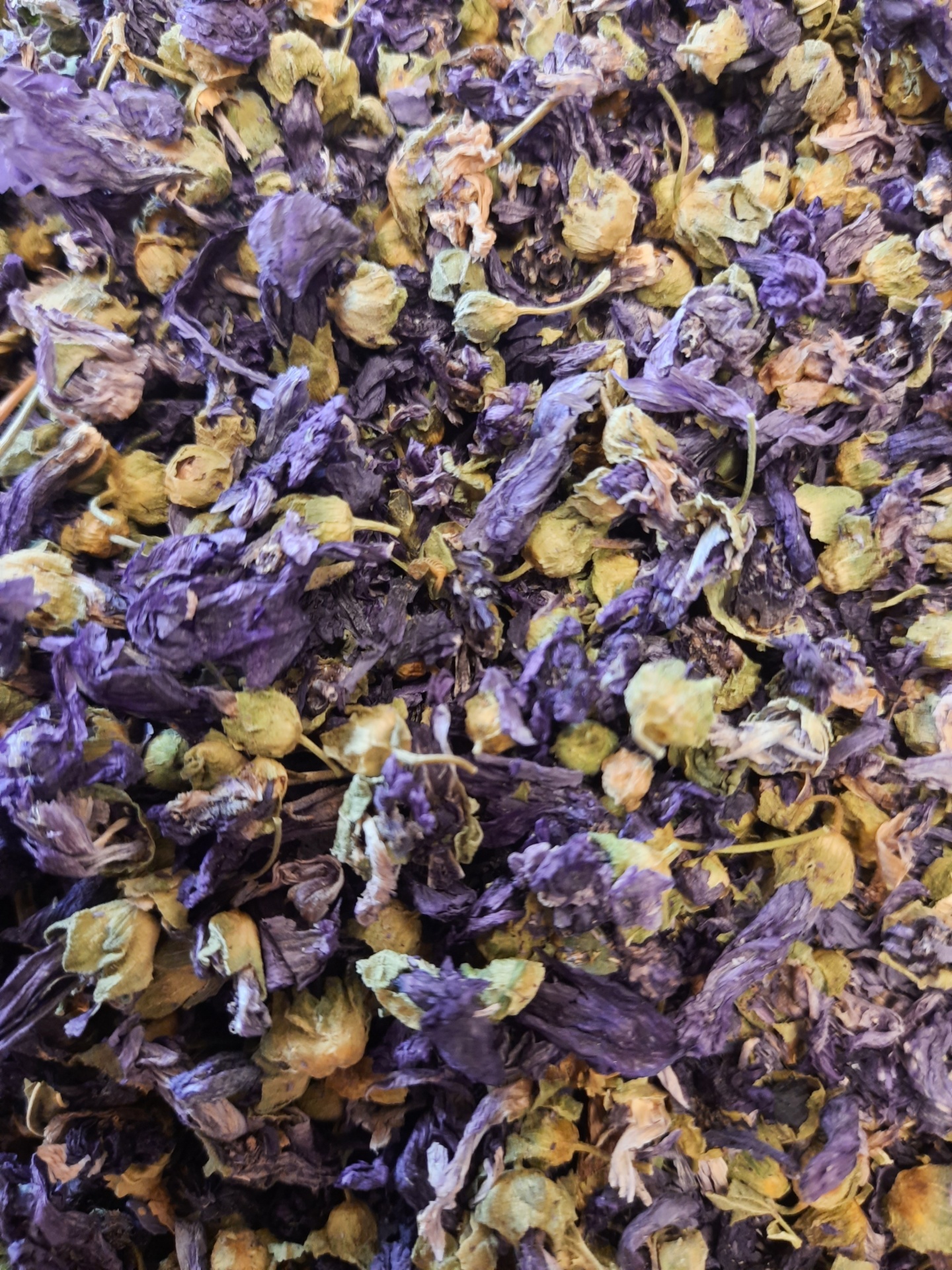 Flores secas roxas e amarelas com textura enrugada em close-up.