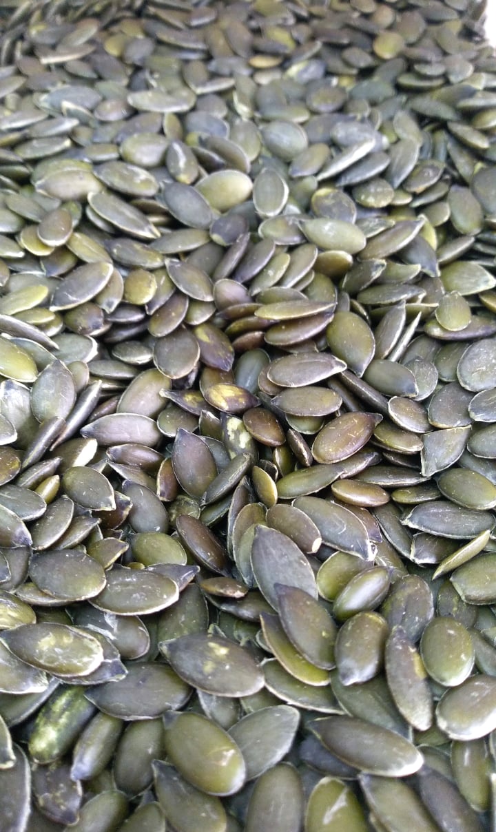 Sementes de abóbora verdes empilhadas umas sobre as outras.