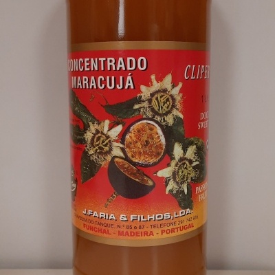 Garrafa de concentrado de maracujá com rótulo colorido e texto legível