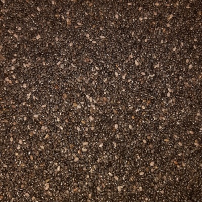 Sementes escuras pequenas com algumas claras, textura rugosa e irregular