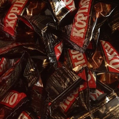 Pacotes individuais de chocolate Kopiko em embalagens pretas com vermelho e branco