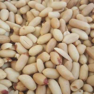 Amendoins descascados bege claro com pontas castanhas-rosadas