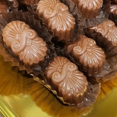Bombons de chocolate com forma de conchas em bandeja dourada