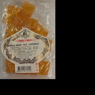 Pacote de doces de mel alaranjados em embalagem transparente com rótulo branco e preto da FABRICA S ANTONIO