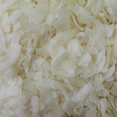 Flocos de coco seco brancos e creme em close-up