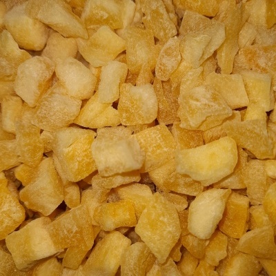 Pedaços pequenos de fruta desidratada amarela e castanha com textura seca e rugosa