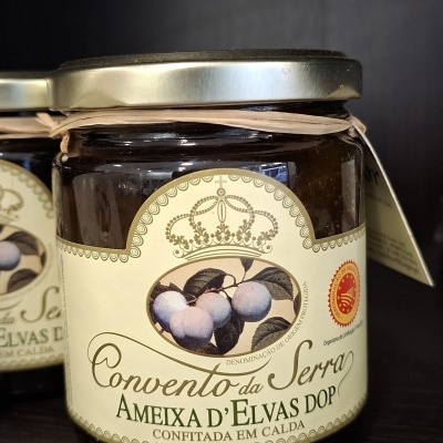 Frasco de vidro com ameixas d'Elvas em calda com rótulo creme e selo de origem