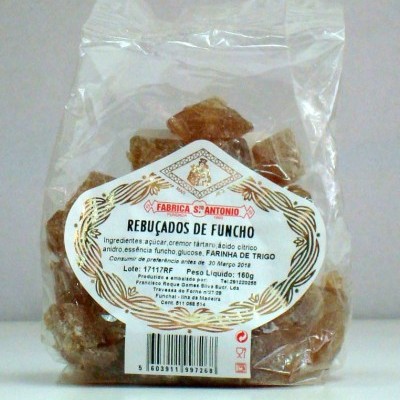 Pacote transparente com rebuçados castanhos e etiqueta branca com texto e margem dourada