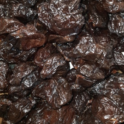 Ameixas secas castanho escuras com textura enrugada