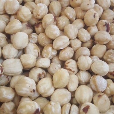 Avelãs descascadas bege claro com algumas marcas castanhas